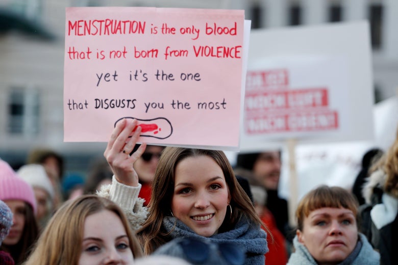 A woman holds up a poster as she takes part in a Women's March in front of the Brandenburg Gate on January 19, 2019 in Berlin.